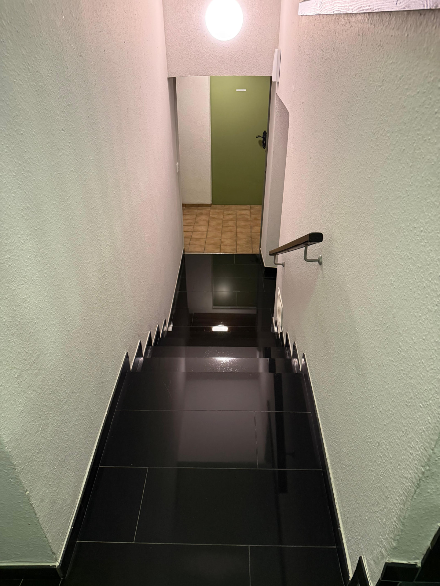 Sauberes Treppenhaus mit schwarzem Fliesenboden